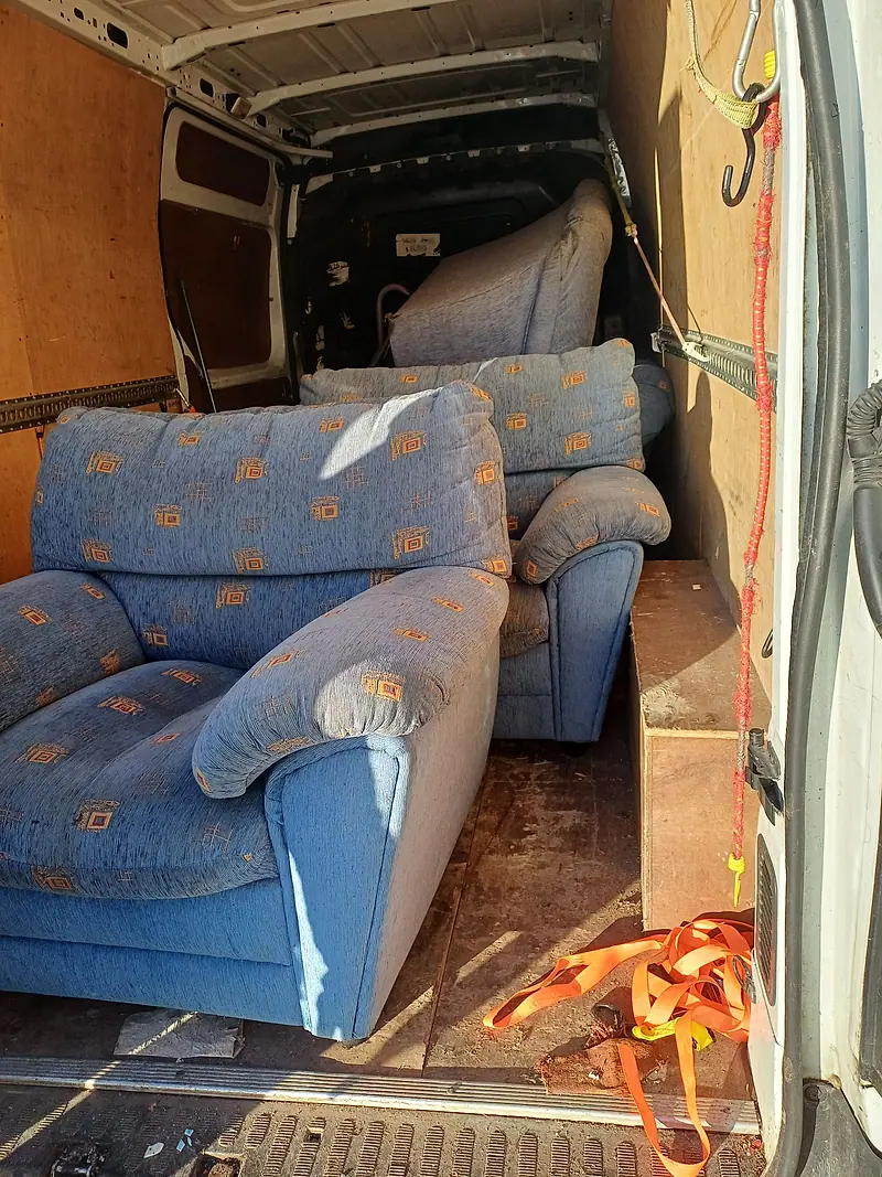 Patterned armchairs strapped inside our removal van