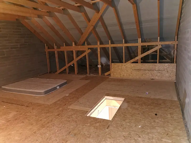 The same attic after the clear-out, the boarded floor clear under the roof trusses