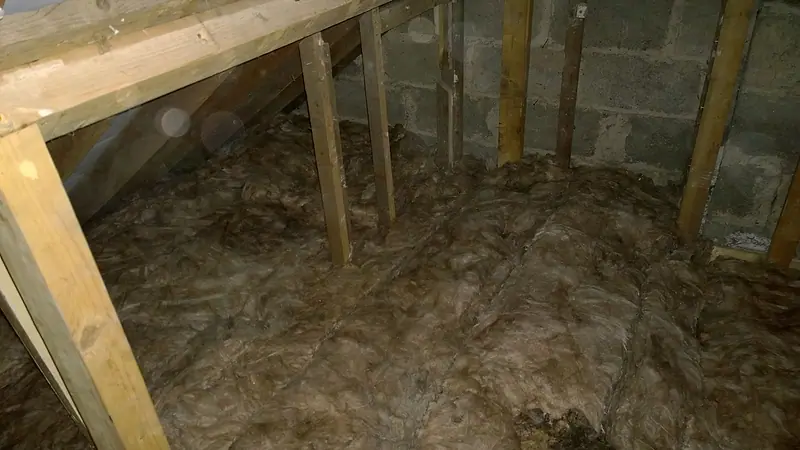 Loft insulation between the joists beside a boarded section of attic floor