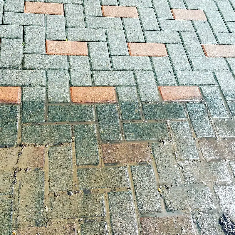 Close-up of red and grey block paving being washed