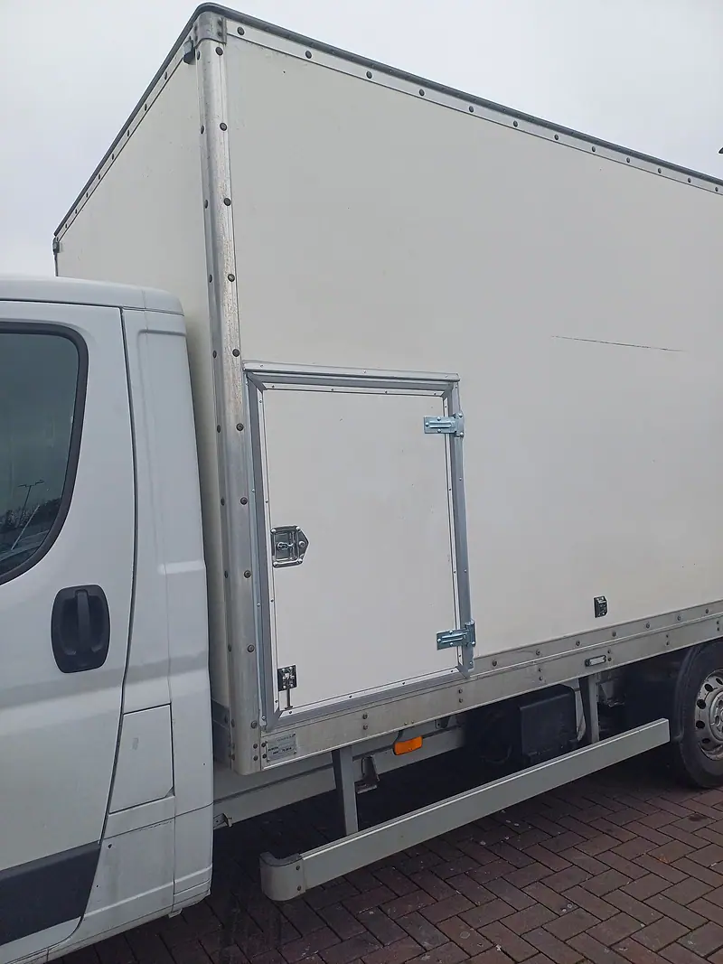 White box-body removal van parked on brick paving
