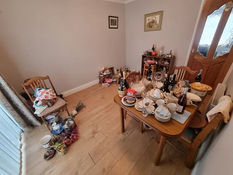 Dining table covered in crockery, glassware and bottles before clearance