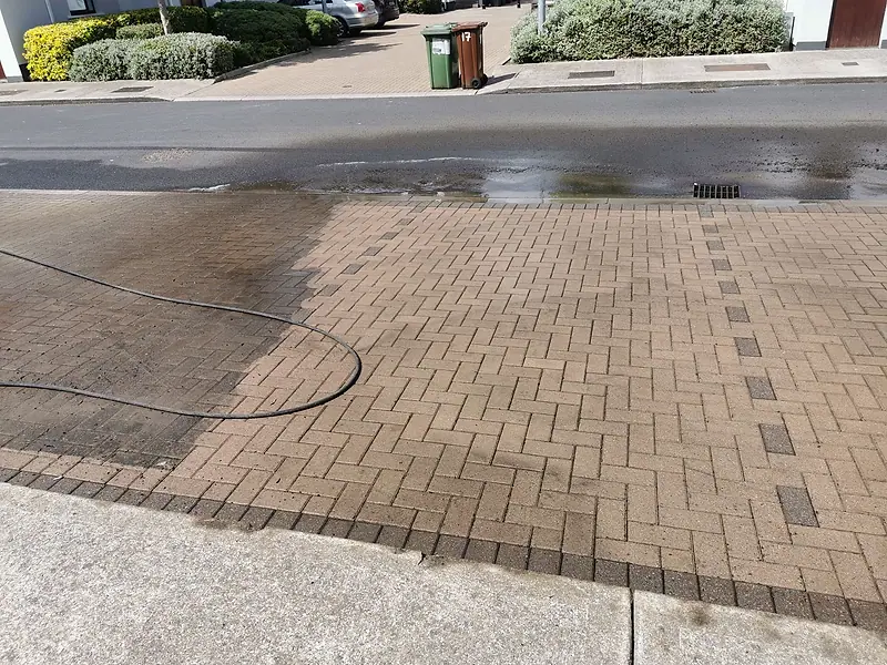 Washed block paving at the front of a house with the dirty edge still visible