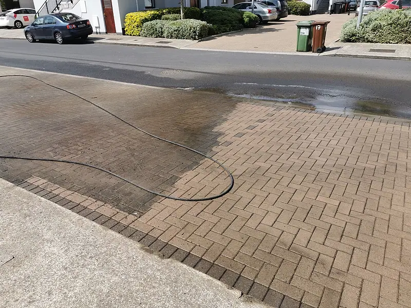 Herringbone block paving with a sharp line between the washed and unwashed areas