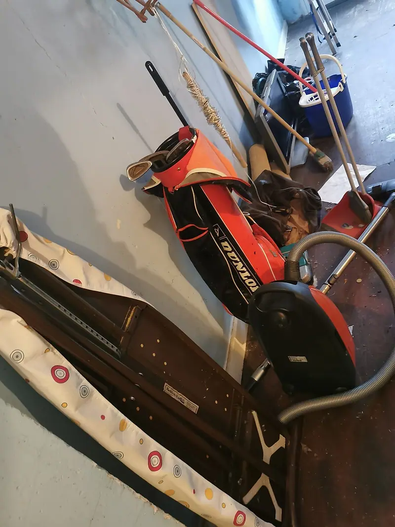 Golf bag, tools and odds and ends stored in a garage awaiting clearance