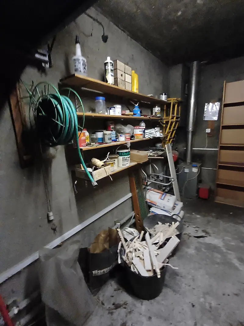 Garage shelving loaded with paint tins, hoses and DIY supplies