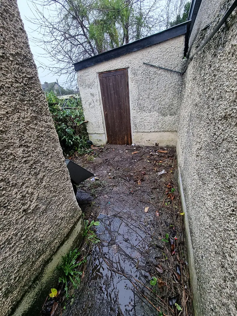 The same side passage cleared, leading to the shed door