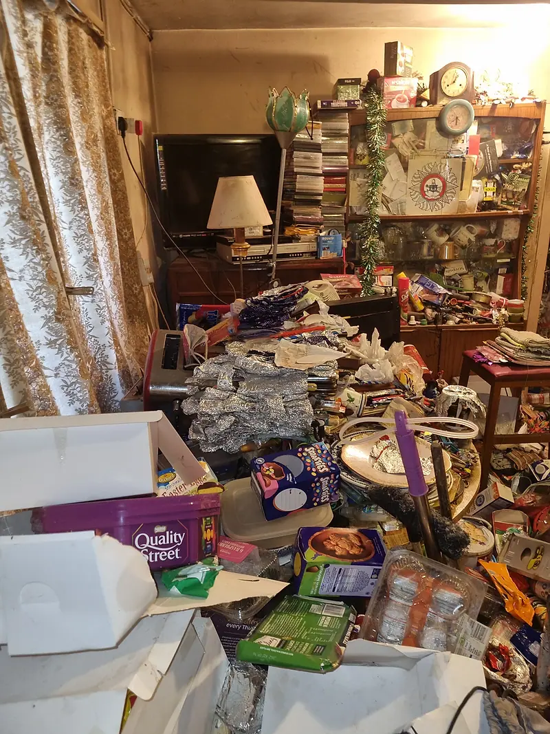 Sitting room with bags, boxes and packaging covering every surface before a sensitive clearance