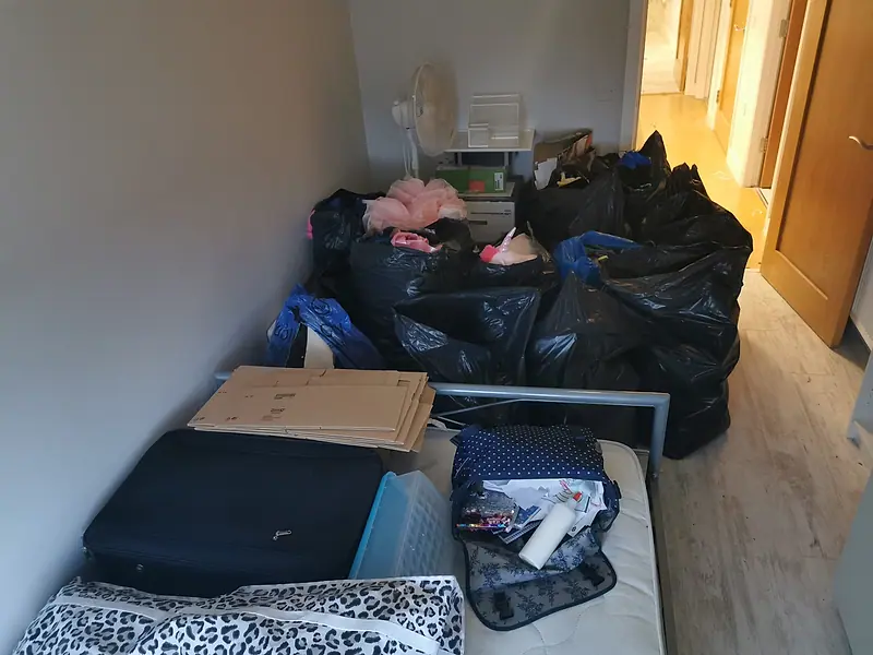 Bagged household items, a suitcase and a mattress grouped for removal