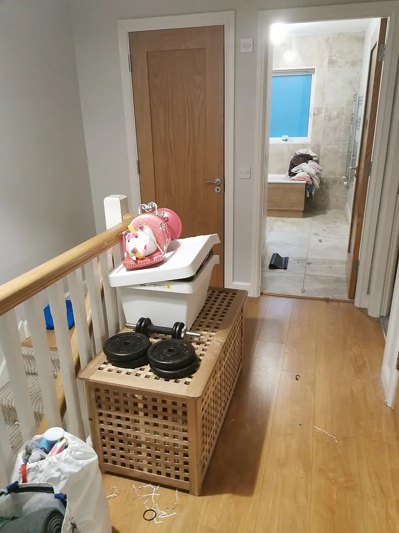 Upstairs landing with a storage box, weights and bags waiting to be cleared