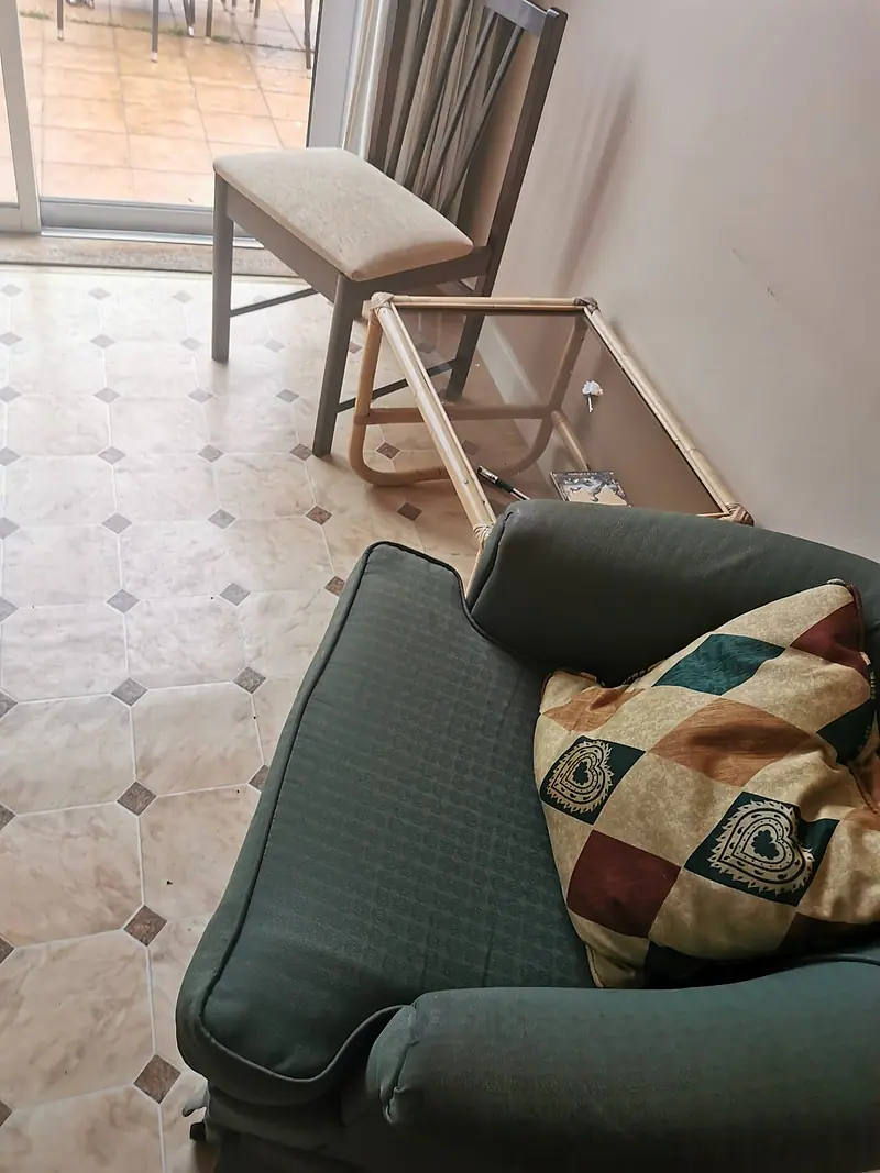 Old armchair and side table in a room being cleared