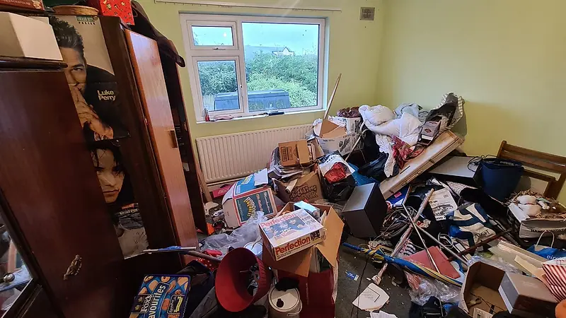 Back bedroom in Sutton before clearance, piled high with bags, boxes and small furniture