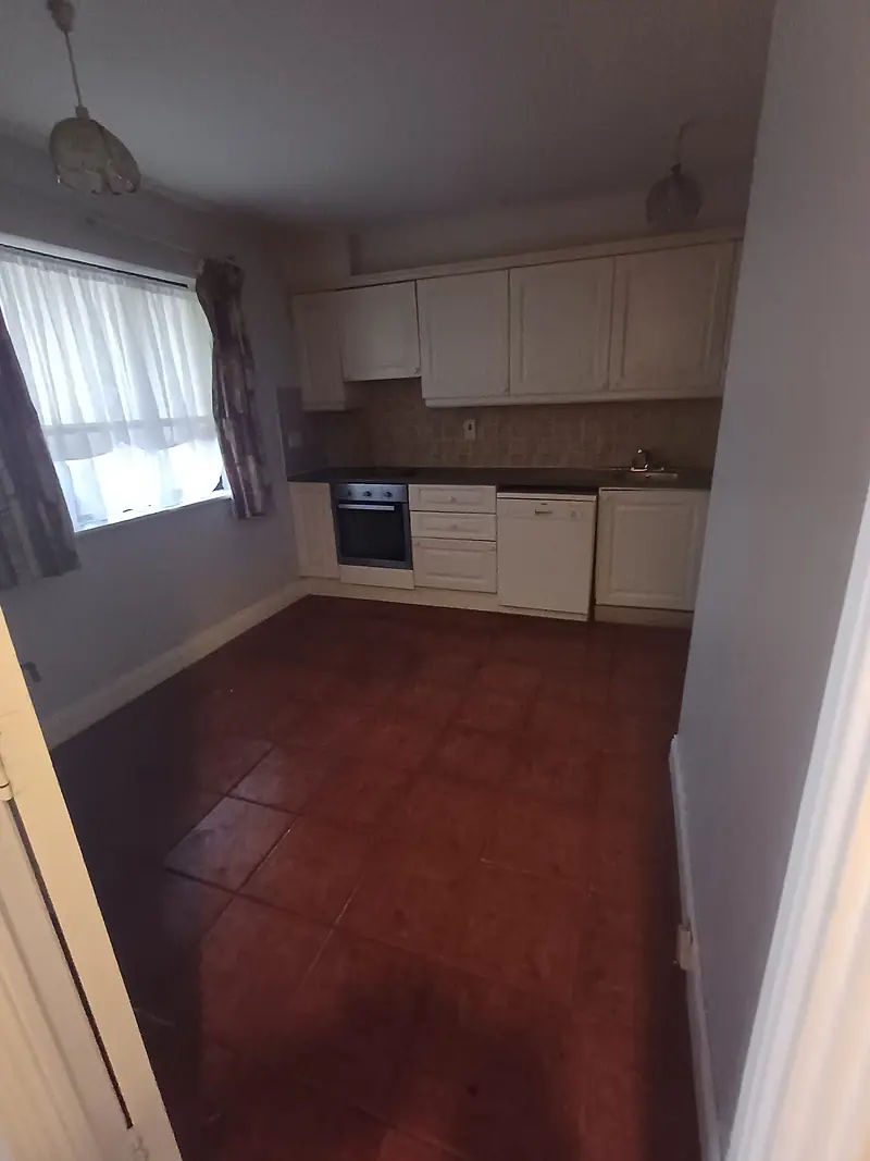 Empty kitchen with a tiled floor after a clearance
