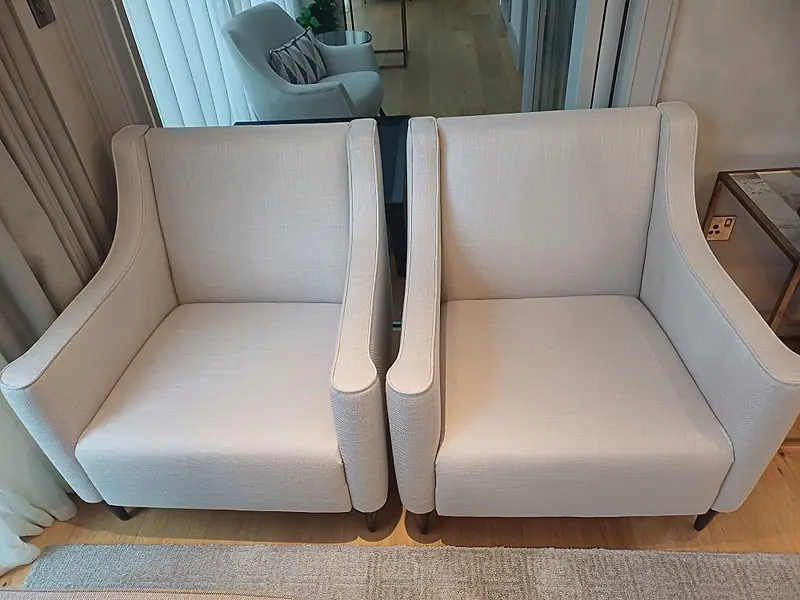 Pair of cream linen armchairs in a modern apartment after cleaning