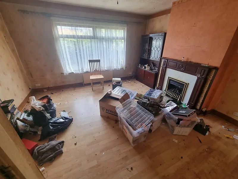 Living room with boxes and bags gathered for removal during a house clearance