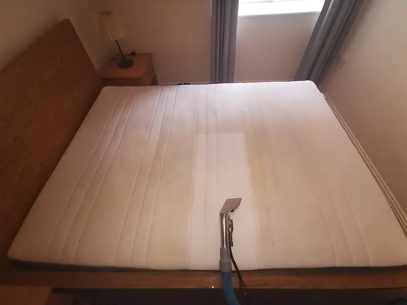 Double mattress being cleaned with a stripe already clean