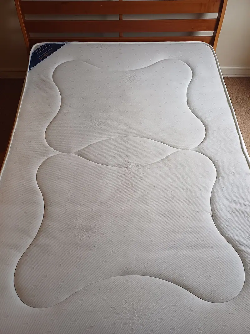Single mattress with faint staining in the centre before cleaning