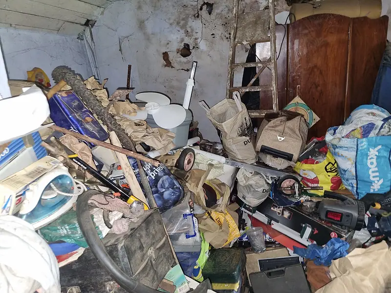 Outbuilding packed with tools, bags, furniture and household junk