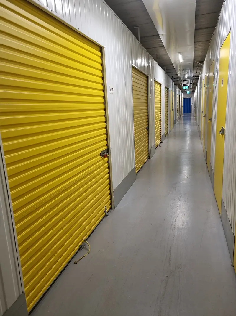 Self-storage corridor with yellow roller-shutter doors