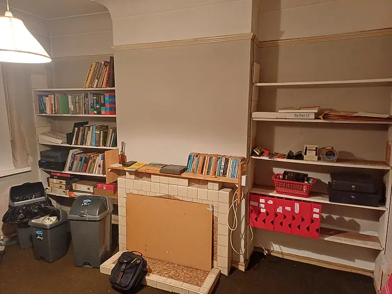 Study with bookshelves, bins and clutter awaiting clearance