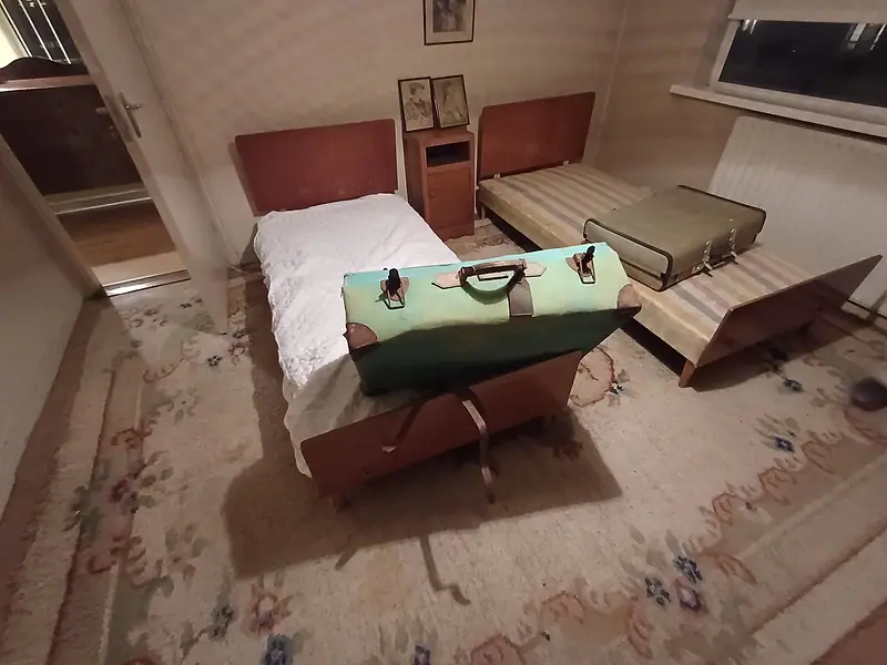 Bedroom with twin beds and old suitcases before a clearance