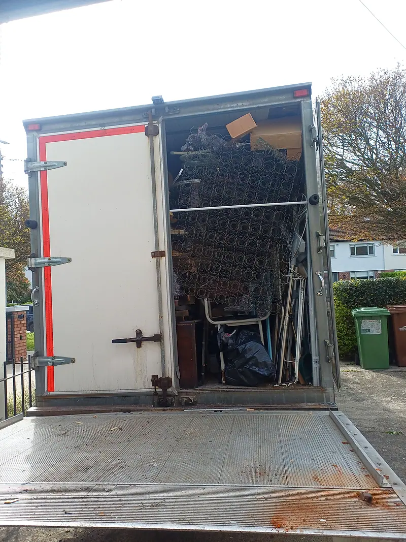 Rear of our box van with the tail lift down, loaded with metal shelving and furniture