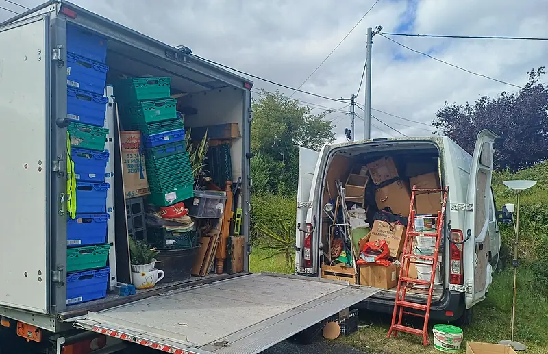 Our box van with tail lift and a panel van, both loaded with crates, boxes and furniture from a house clearance