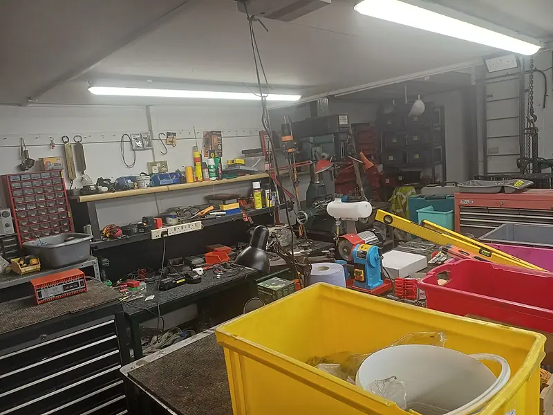 Workshop packed with tools, toolboxes and storage crates before clearance